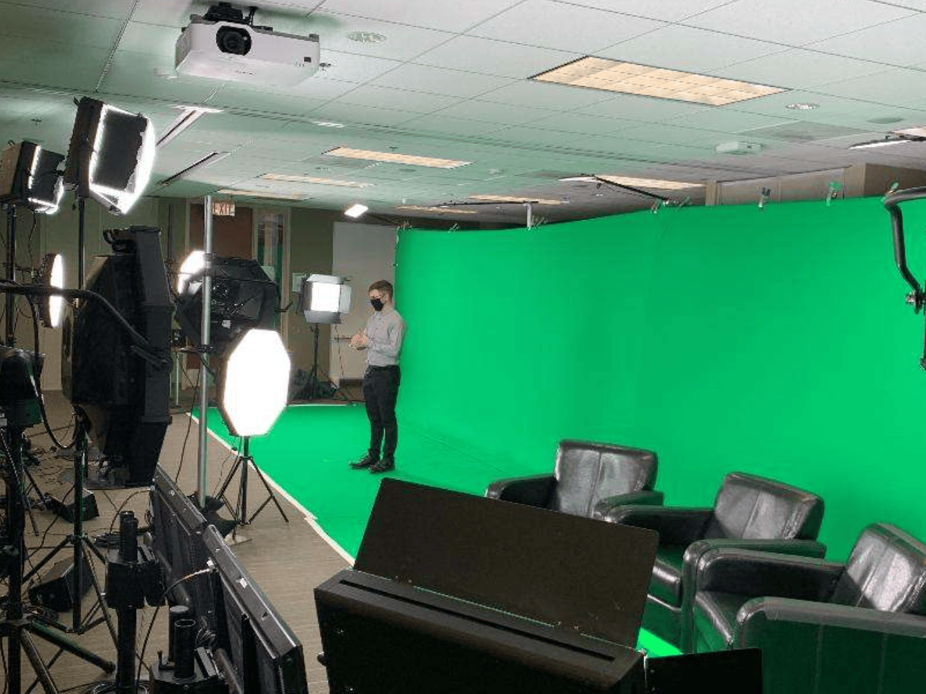 A person standing in front of a green screen