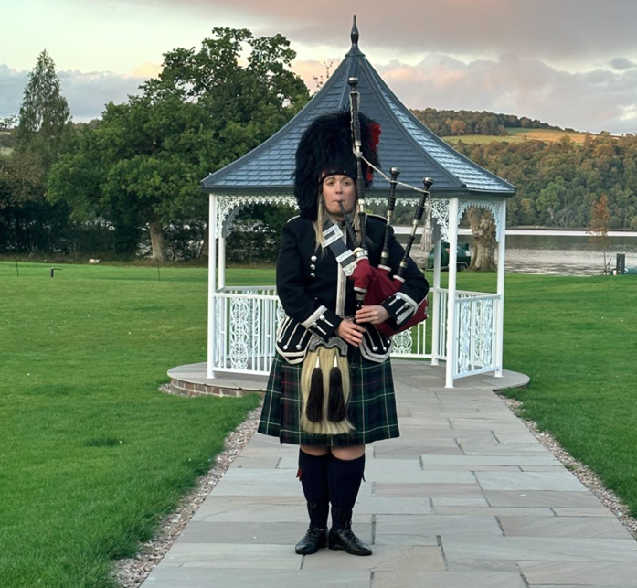 A person playing bagpipes on a path